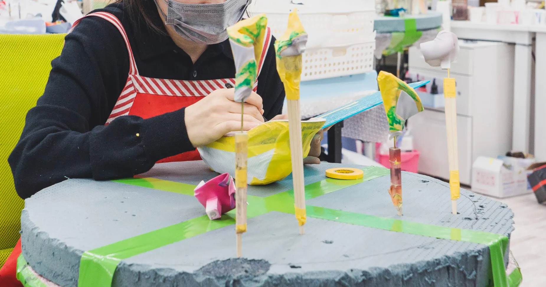 棒に付けたパーツに色をのせる作業